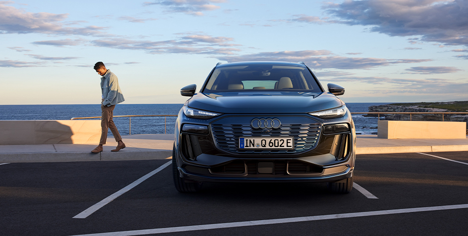 Audi Q6 steht auf einem Parkplatz vor dem Wasser